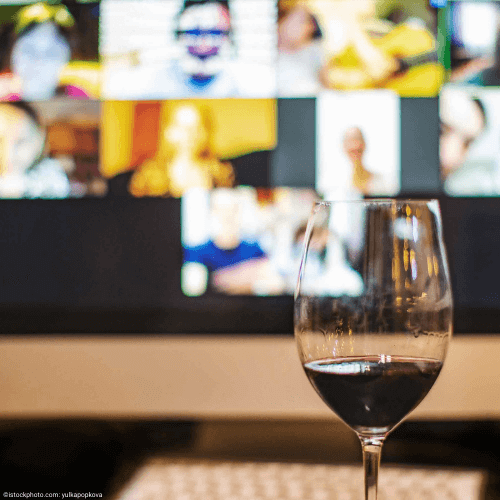 Mit Rotwein befülltes Weinglas vor Bildschirm mit vielen Videochat-Fenstern bei private Wein Events